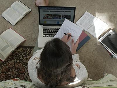 An overhead photo of an online college student learning at home.